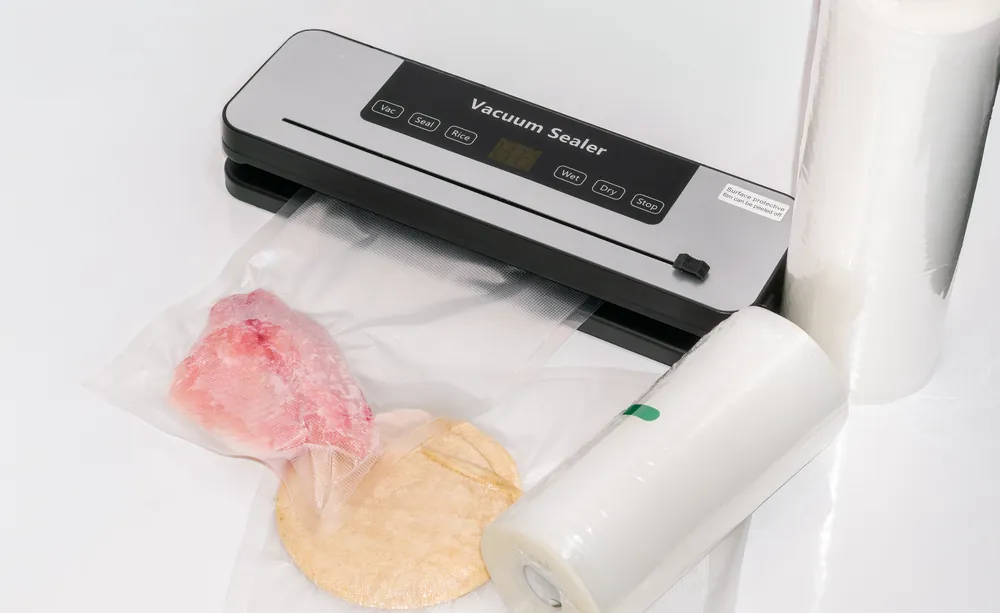 Máquina para empaque al vacío empacando filete de pescado y tortillas
